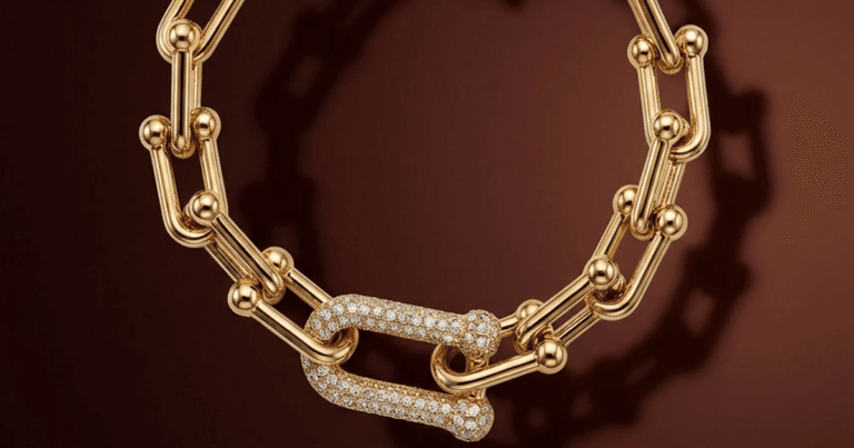 Fotografia profissional de um colar de elos banhado a ouro com fecho cravejado. Imagem de alta qualidade demonstrando o padrão visual do aplicativo JoiasLab para o catálogo da Pedra Bruta Semijoias.